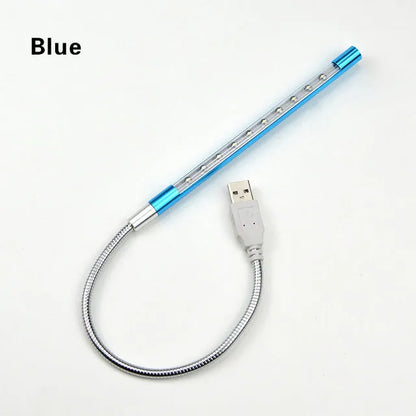 Spiral shaped silver aluminium USB LED desk lamp bent on a wooden desk.