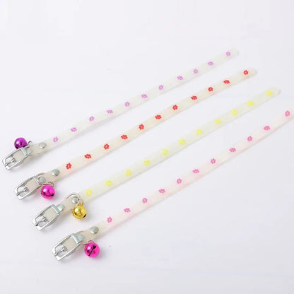 Glowing adjustable luminous collar for cats on a dark background, showing silicone chain and metal bell.