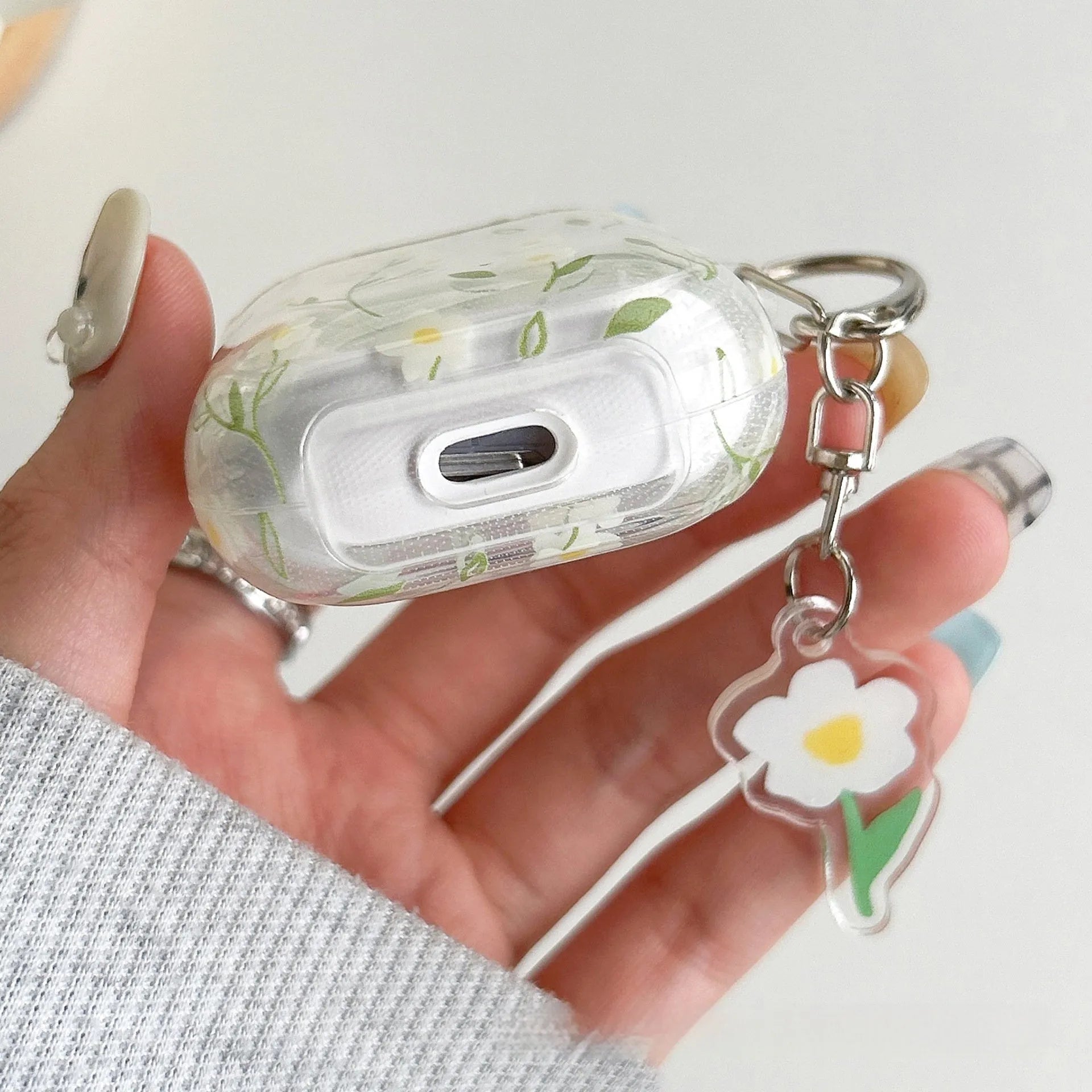 Clear white floral TPU protective cover on an Apple AirPods Pro charging case.