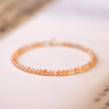 Women's ultra-thin 3mm Sunstone bead bracelet on wrist, showing natural crystal and delicate design.