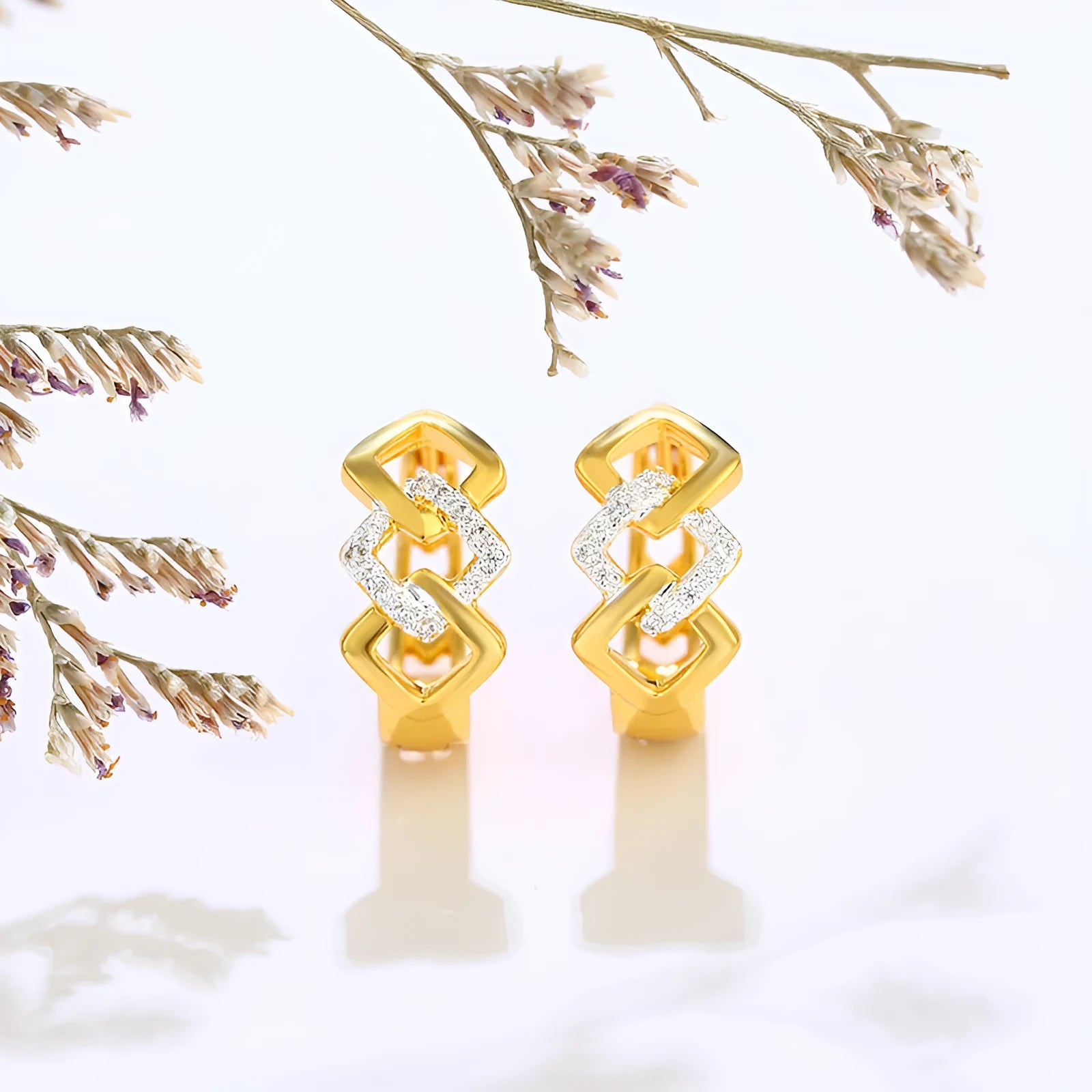 Pair of gold-coloured geometric alloy stud earrings with a hollow-out design on a plain background.