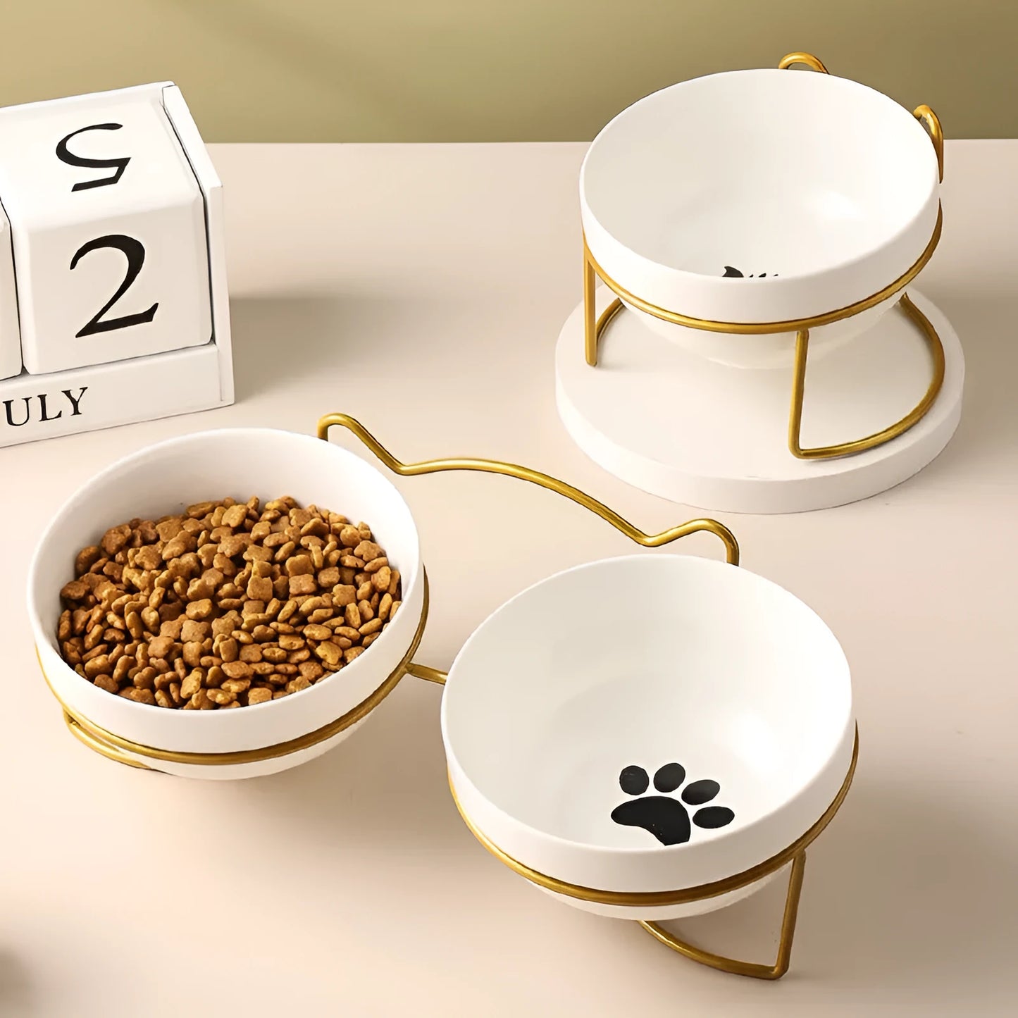 White ceramic pet bowl with cat paw print in a black iron stand with cat ear details