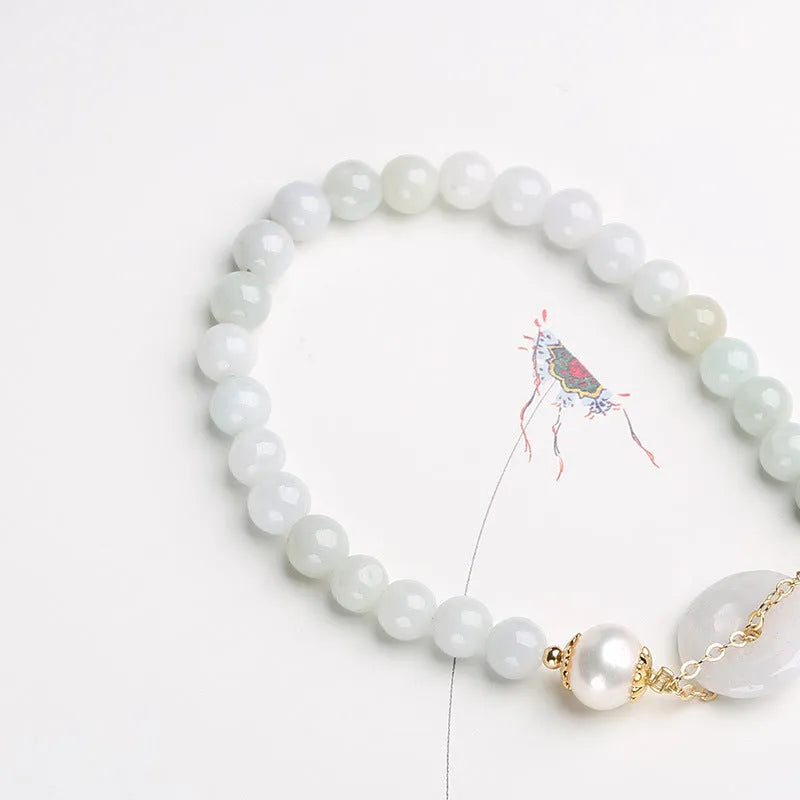 Natural jade bracelet with a geometric peace buckle clasp and round pendant.