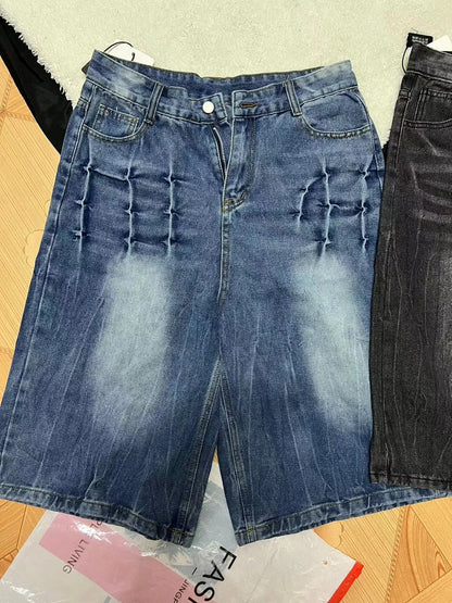 Man wearing loose light blue washed denim shorts with a straight leg and cropped length.