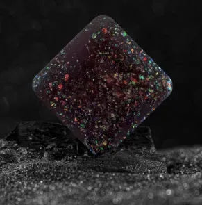 Galactic edition pocket gyro desk toy on a surface, showing its quadrilateral resin construction and celestial colour design.