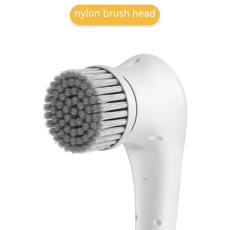 White cordless electric handheld scrubber with five attached brush heads on a kitchen counter