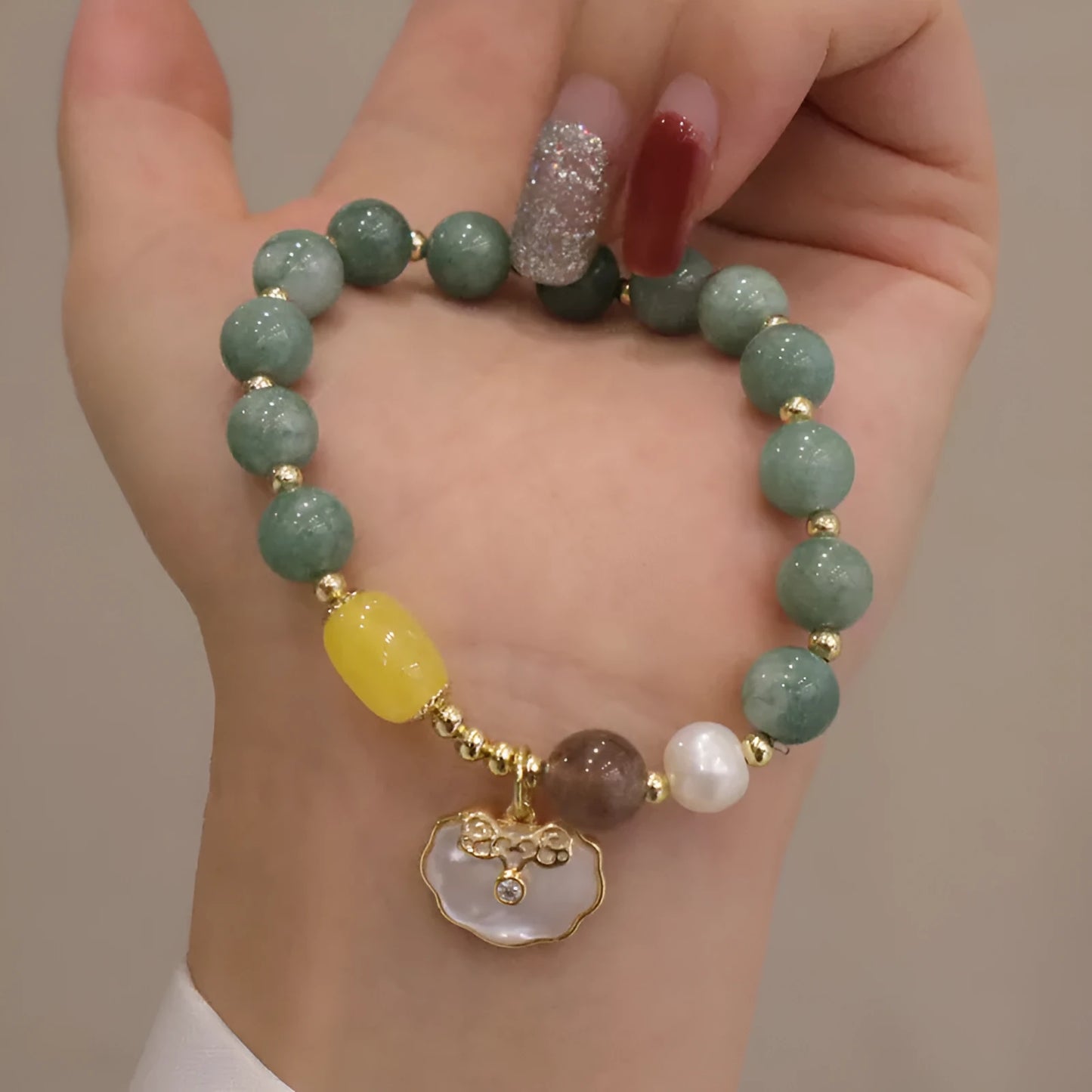 Light green jade bead bracelet with a shell charm and adjustable metal clasp.