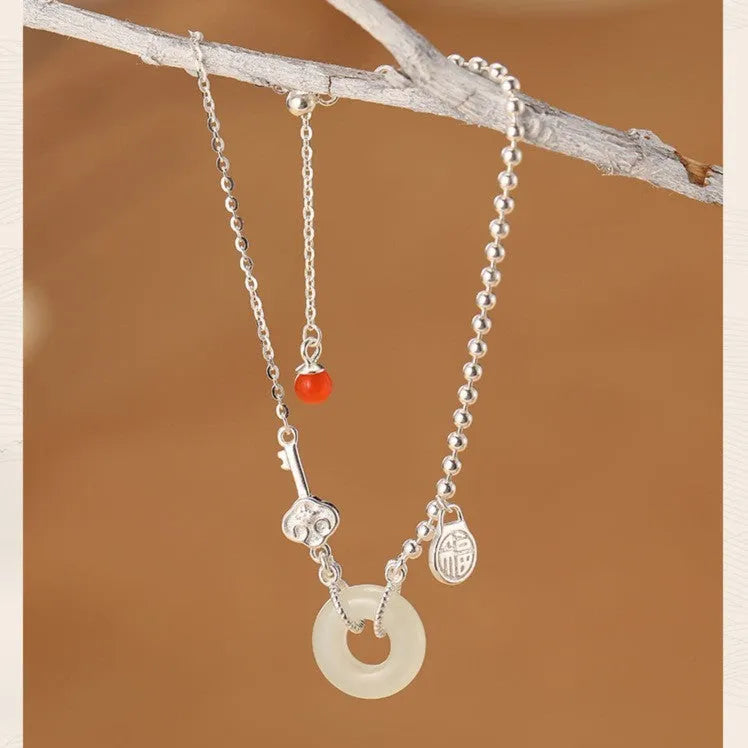 Silver women's bracelet with Hetian jade stones and a geometric peace buckle charm.