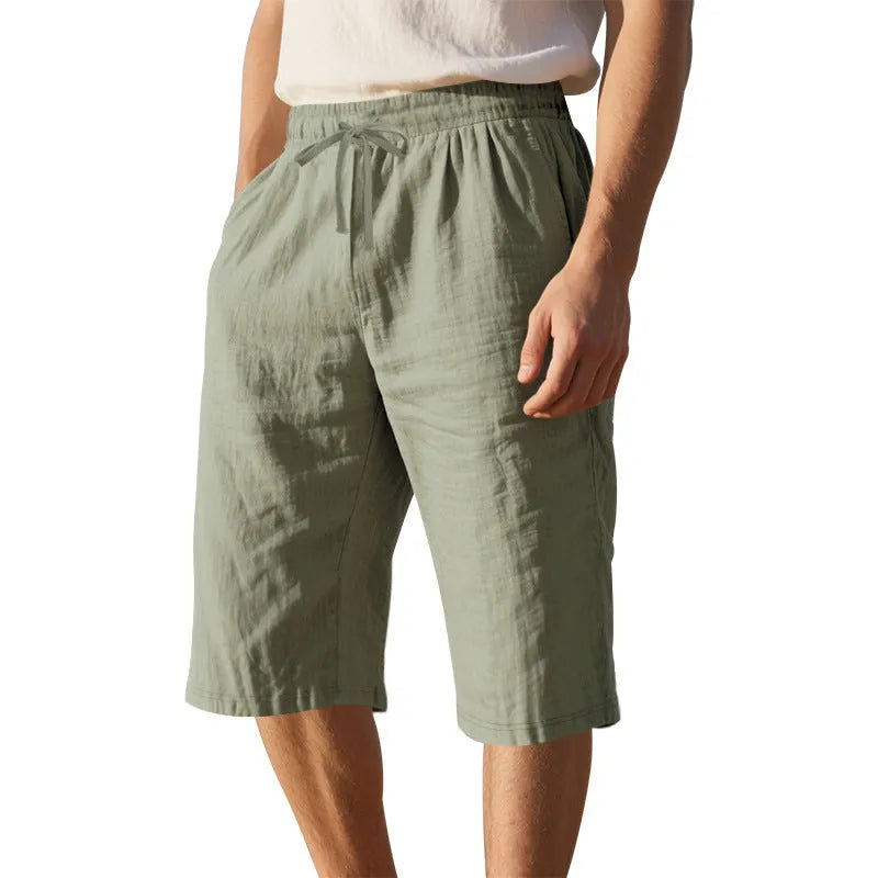 Men's loose-fit linen shorts in a solid colour with a drawstring waist and cropped leg length.