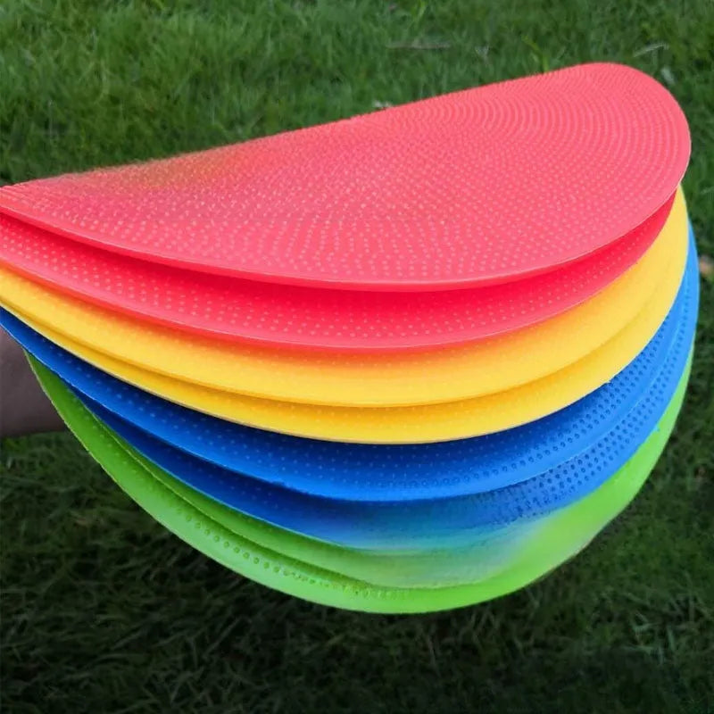 Soft yellow TPE football training landmark pad disc on grass, 23cm diameter.