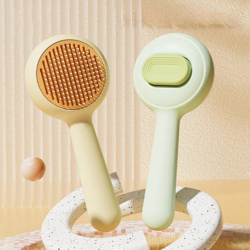 Green and yellow handled cat grooming brush with stainless steel pins on a white background
