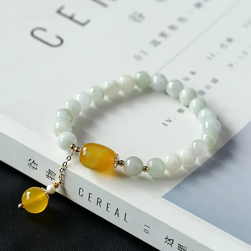 Geometric ethnic-style women's bracelet with hanging agate tassel featuring 7.5mm round beads in red or yellow agate and 14K gilded elements for a distinctive bohemian accessory