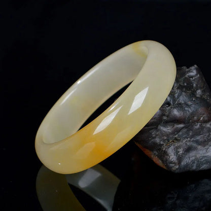 A polished natural jade bracelet in a traditional Chinese style, shown with a size guide for 54mm to 62mm.
