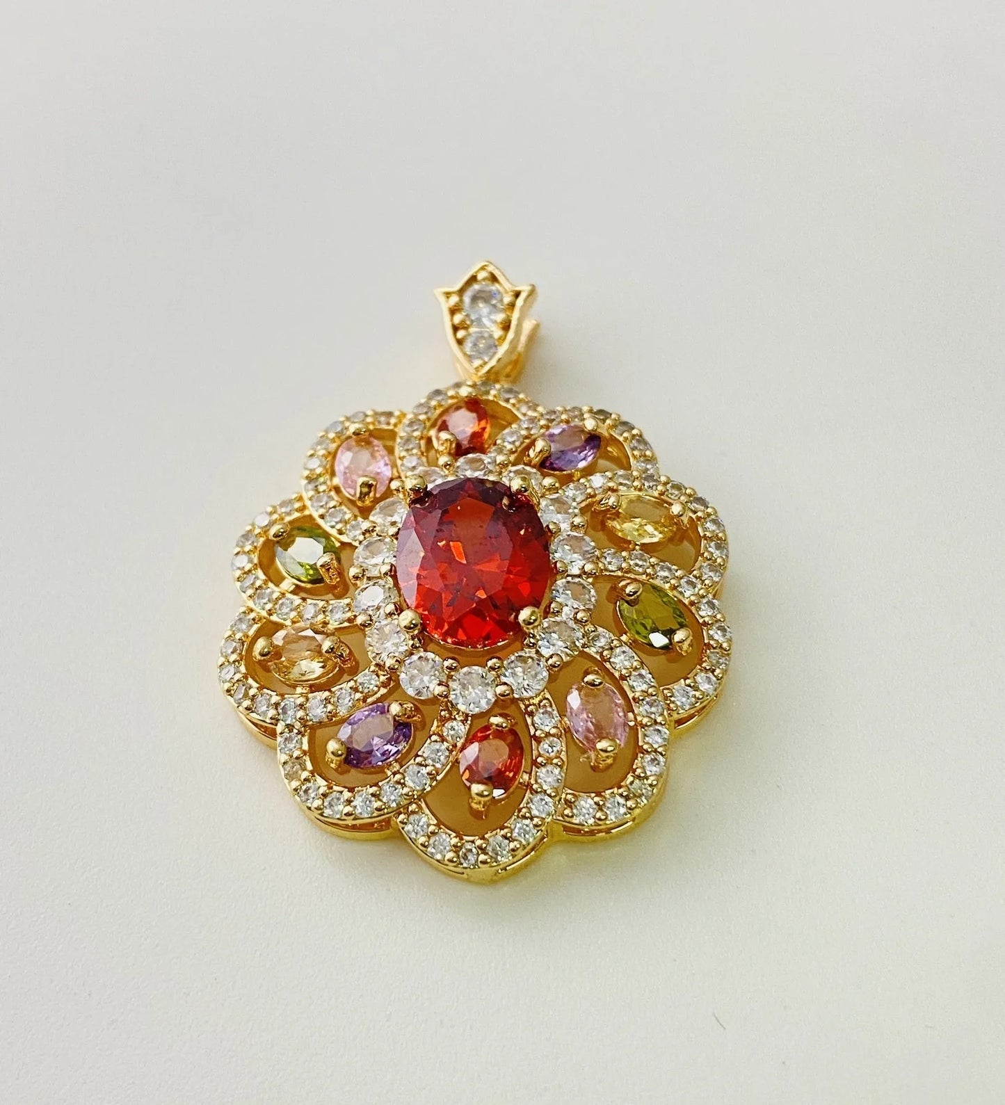Close-up of a women's flower-shaped pendant necklace with a colourful zircon stone in a choice of gold, champagne gold, or platinum colour finishes.