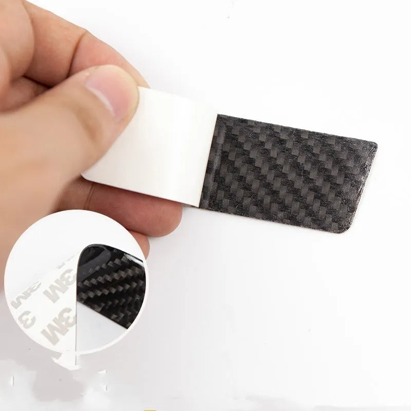 Set of four carbon fibre texture adhesive door handle protectors for Tesla Model S interior.