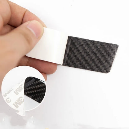 Set of four carbon fibre texture adhesive door handle protectors for Tesla Model S interior.