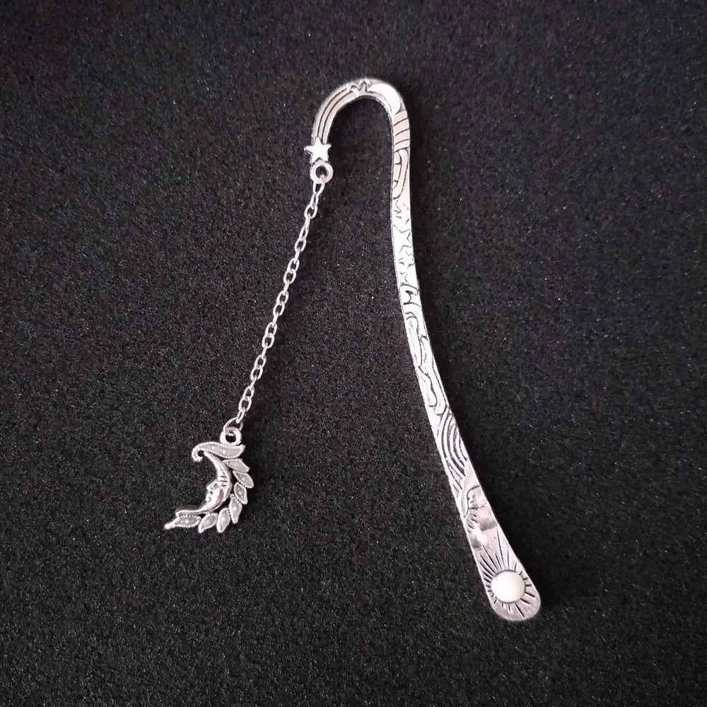 Retro five-pointed star glowing metal bookmark in ancient silver and bronze finishes on an open book.