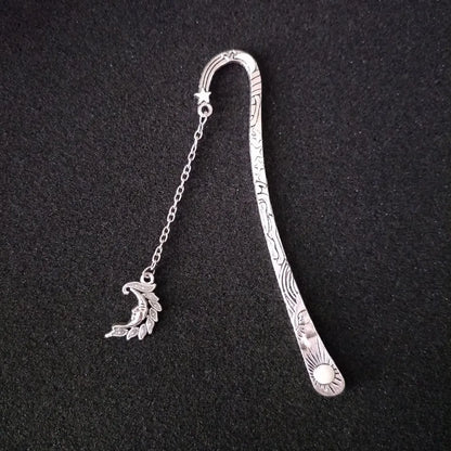 Retro five-pointed star glowing metal bookmark in ancient silver and bronze finishes on an open book.