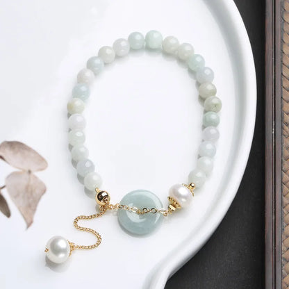 Natural jade bracelet with a geometric peace buckle clasp and round pendant.