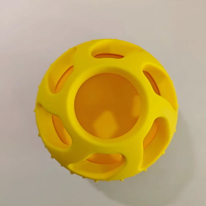 Yellow silicone pet slow feeding ball with treat-dispensing moulded interior for dental cleaning