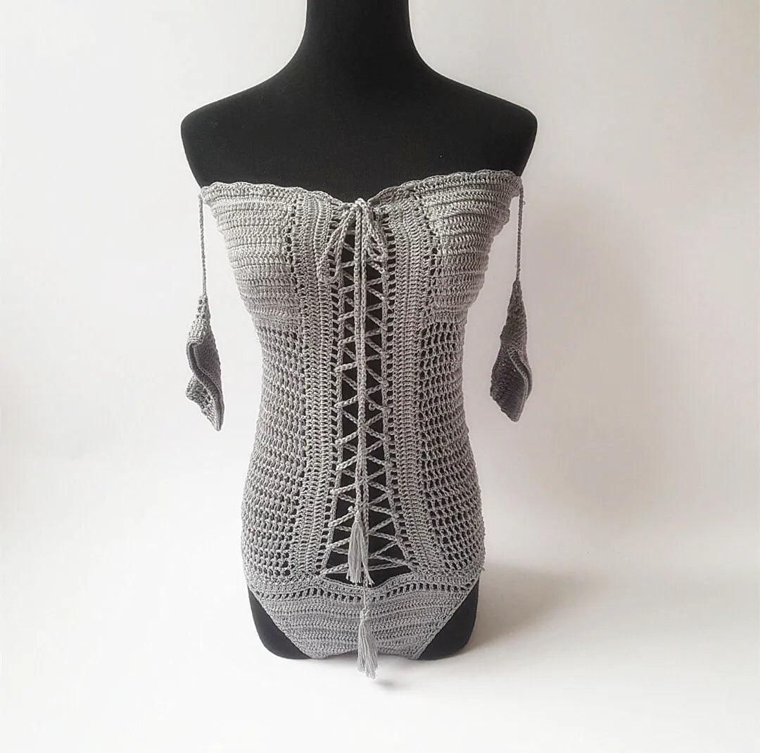 Off-shoulder one-piece swimsuit in aqua green on a mannequin, showing European/American cut and secure neckline.