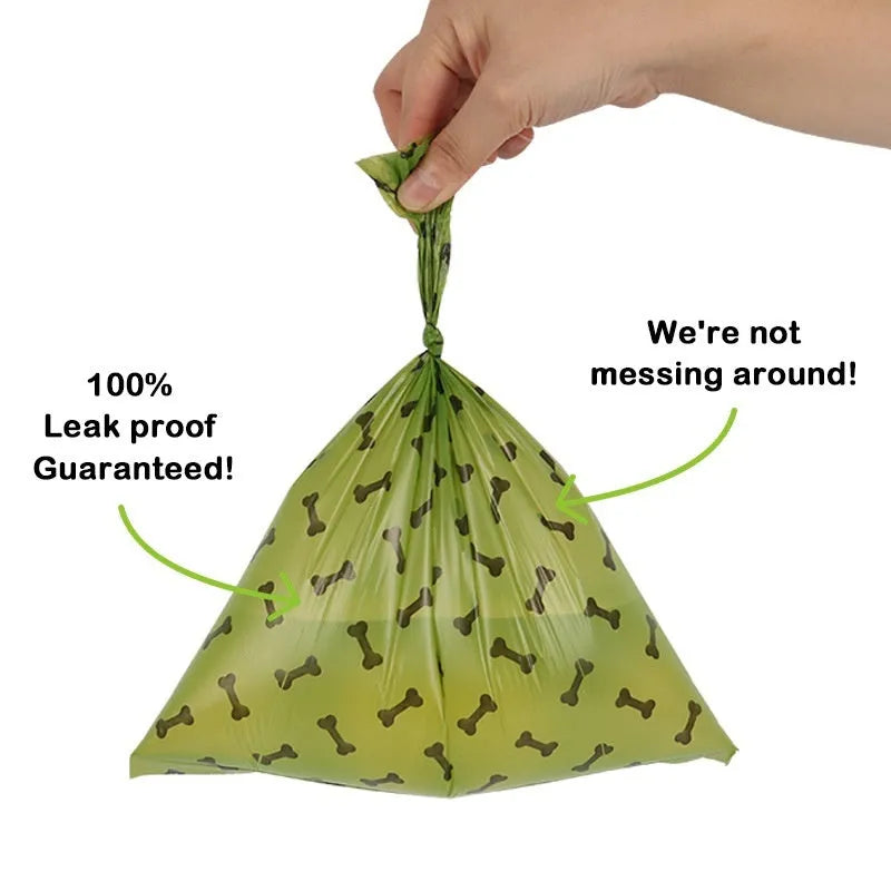 Roll of military green degradable dog poop bags with black bone print, shown next to a plastic dispenser.