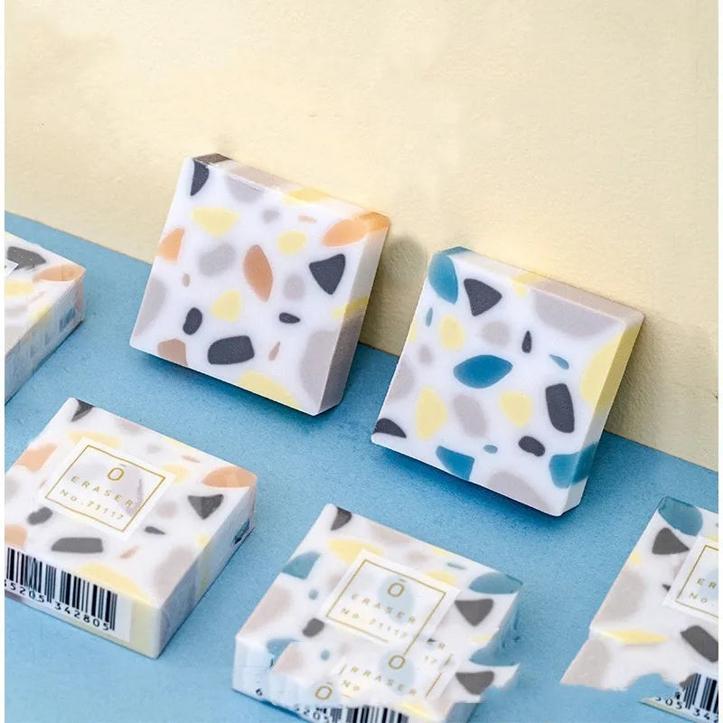 White rectangular rubber brick eraser for students on a blue background.