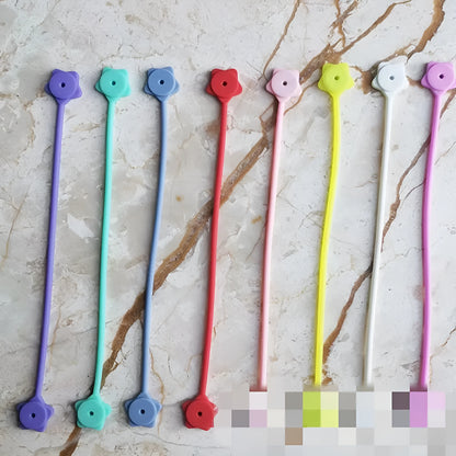 Silicone magnet wire winder for cable organisation in assorted colours on a white background.