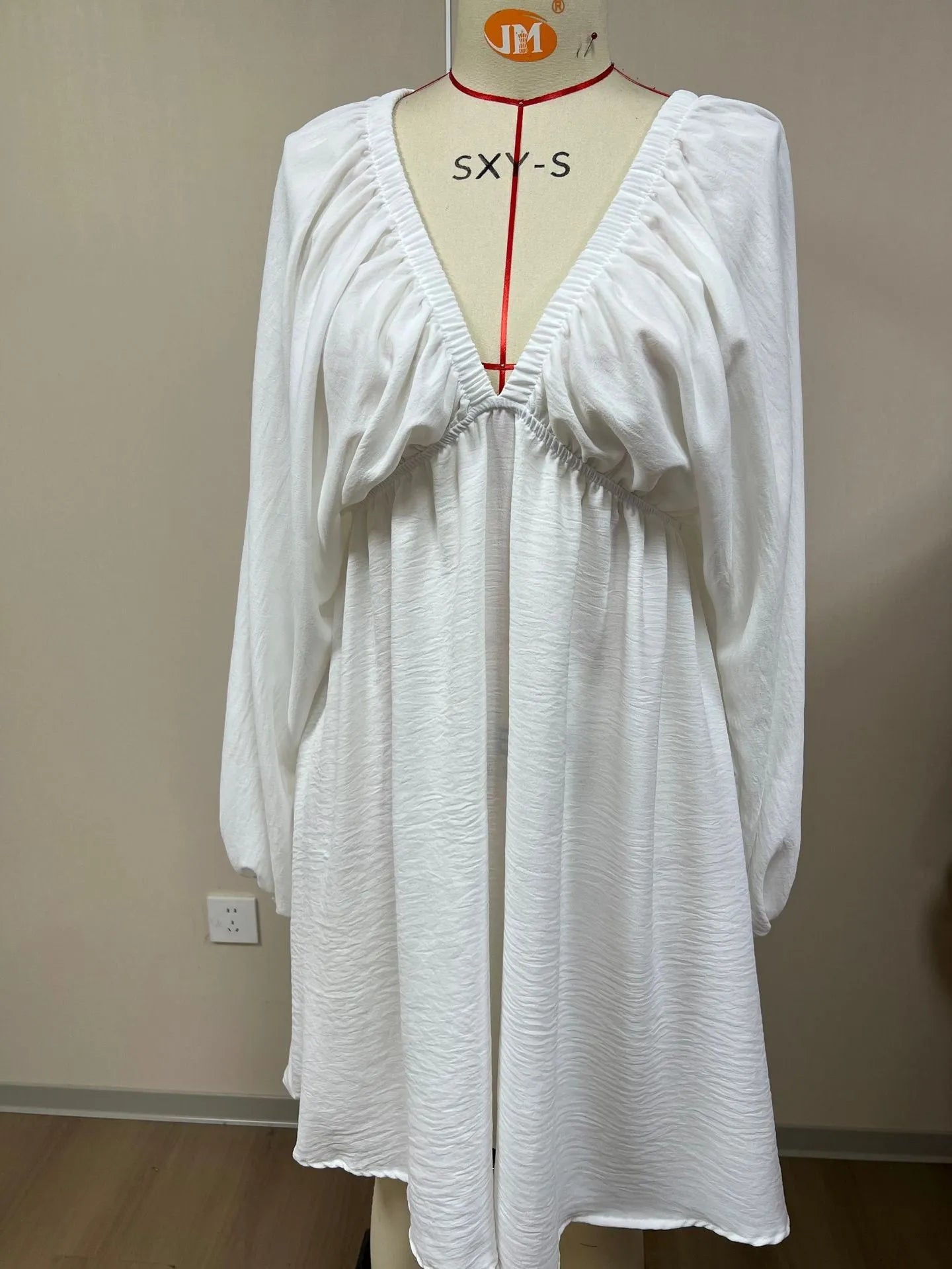 Women's apricot V-neck dress with long puff sleeves and a flounced swing skirt.