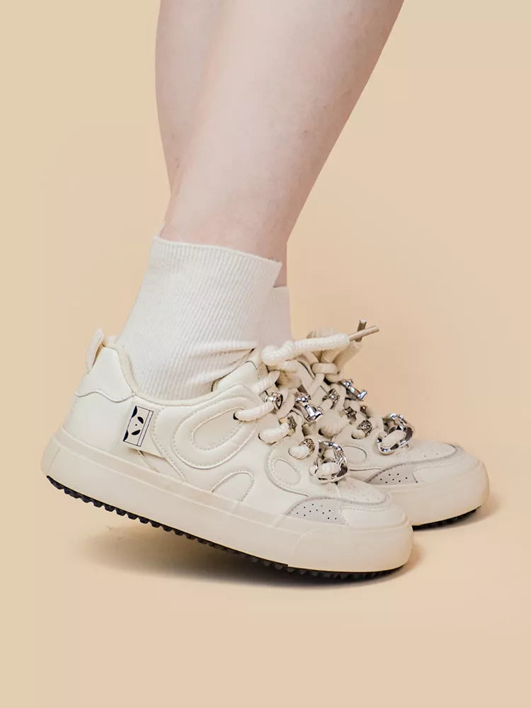 Women's white low-top sneakers with rubber sole and lace-up closure
