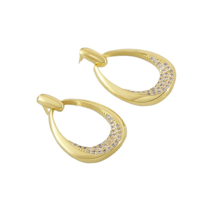 Women's yellow gold geometric drop earrings with oval and round elements on a white background.