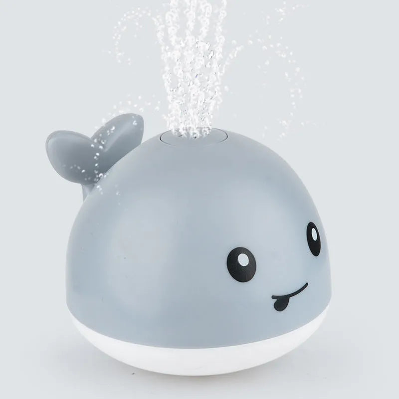 Grey or white electric whale bath toy spraying water with LED lights on a base.