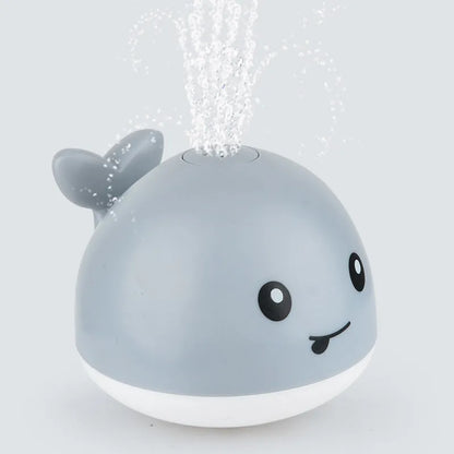 Grey or white electric whale bath toy spraying water with LED lights on a base.