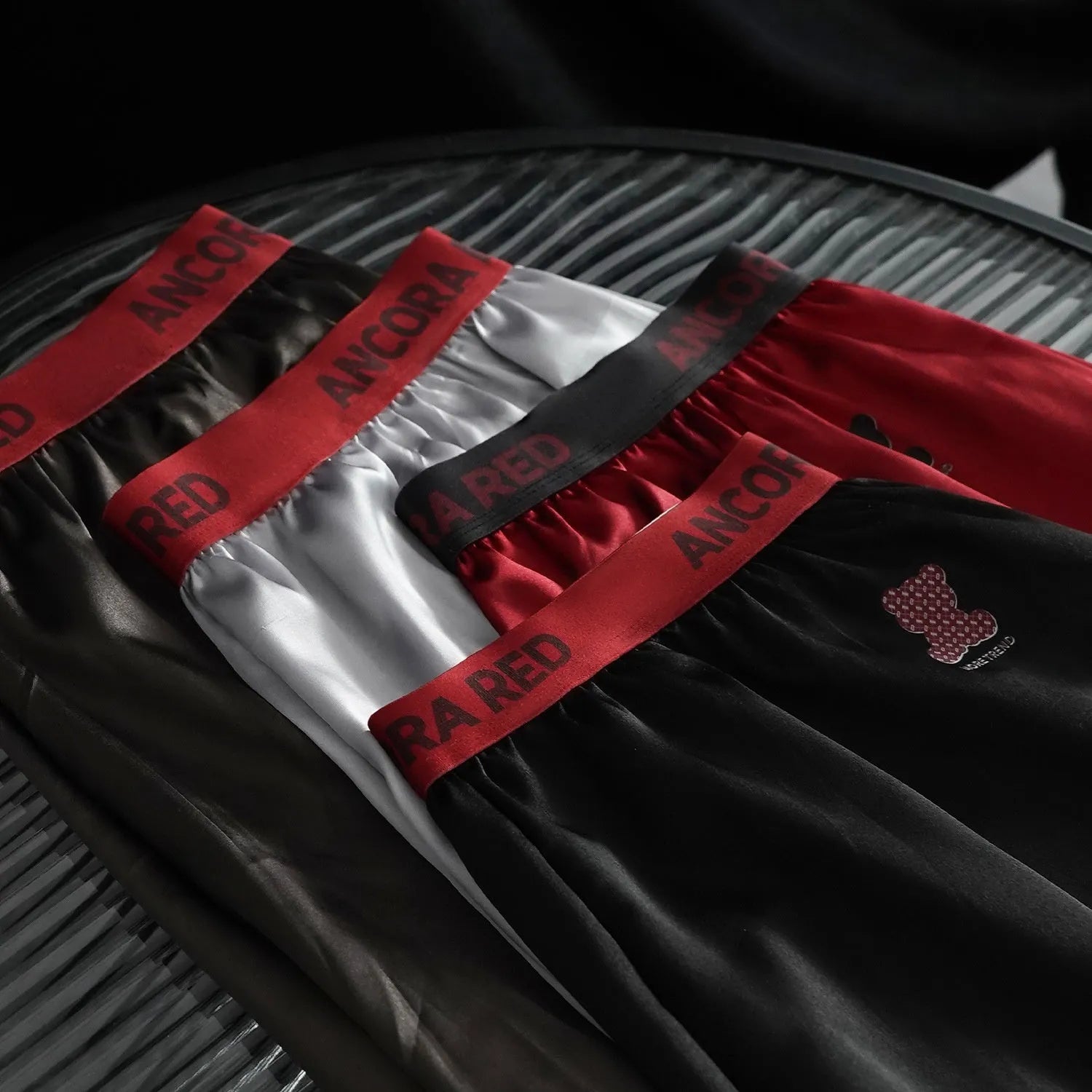 Men's solid colour boxer briefs in black, shown flat, highlighting the mid-waist design and knitted fabric texture.