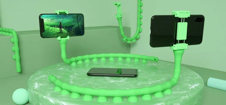 Black flexible rubber phone holder with suction cup extended on a desktop