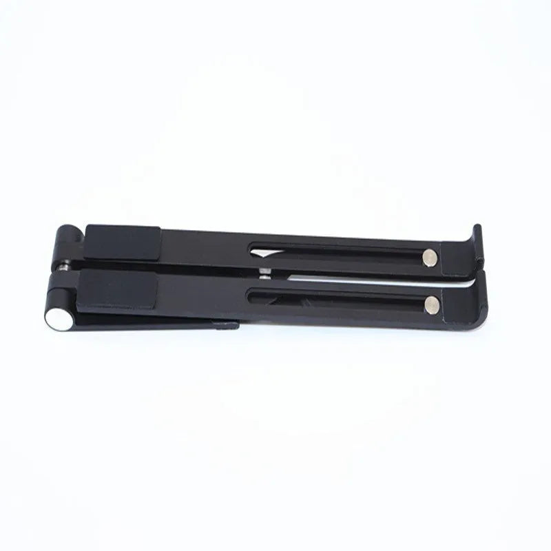 Black aluminium laptop stand on a wooden desk next to a notebook