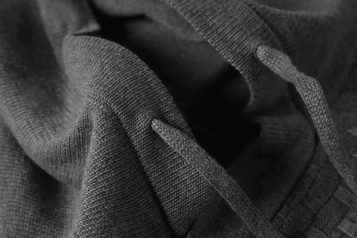 A man wearing a cotton-polyester blend hoodie available in nine colours including black, navy, and red.