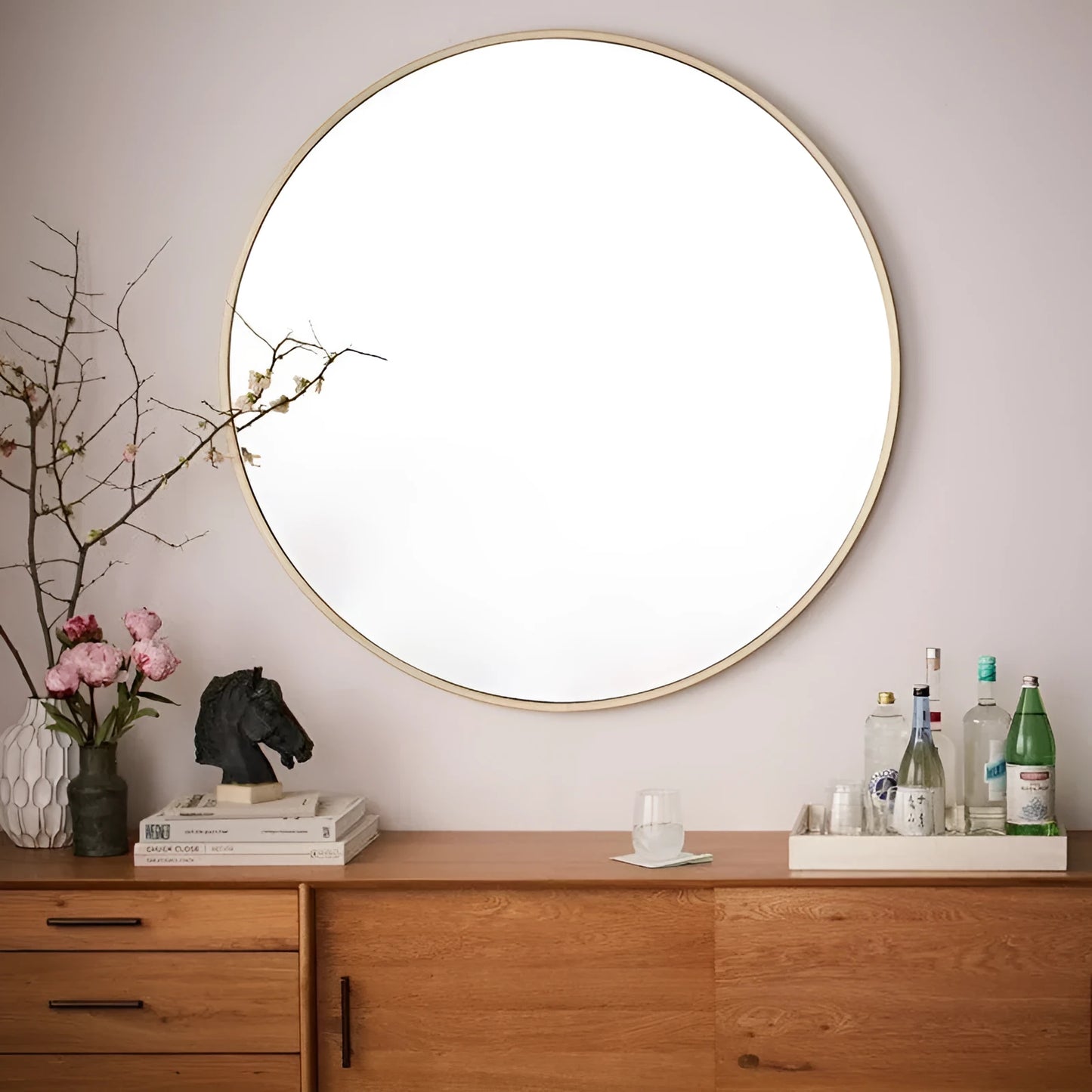 Round metal-framed wall mirror in black, white, or gold for bathroom.