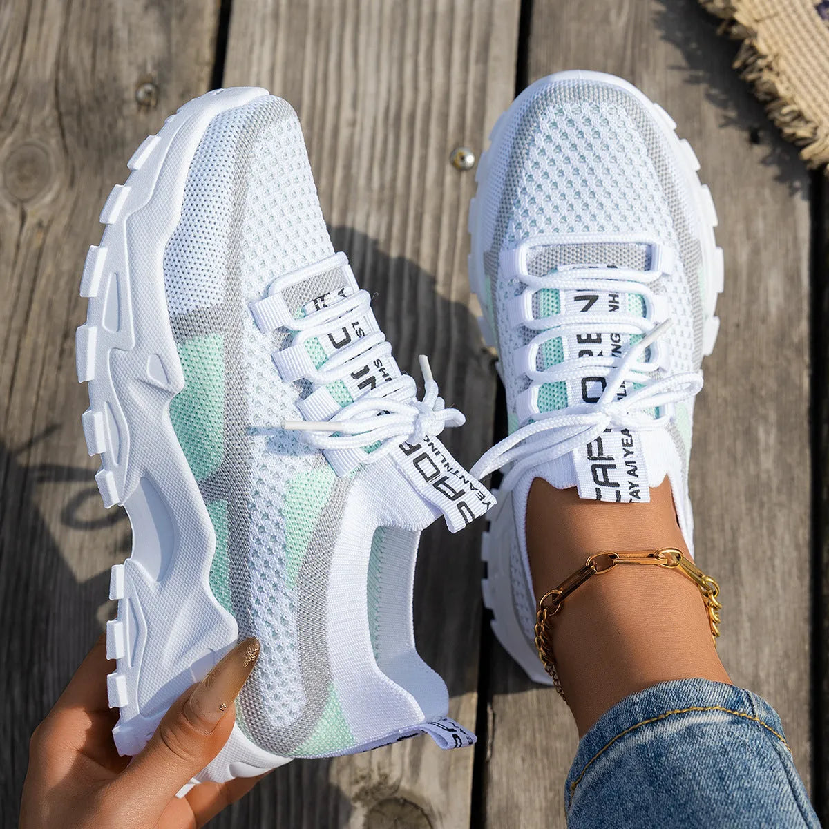 Women's Flyknit mesh lace-up sneaker in a grey colourway showing round toe and rubber sole.