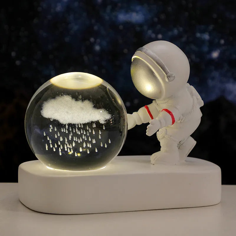 Glowing astronaut crystal ball night light with 6cm diameter and USB cable on wooden surface