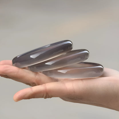 Dark gray Brazilian agate women's bracelet with circle and ring design on a wrist.