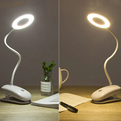 A modern white clip-on rechargeable desk lamp with a touch-sensitive switch and a plastic shade.