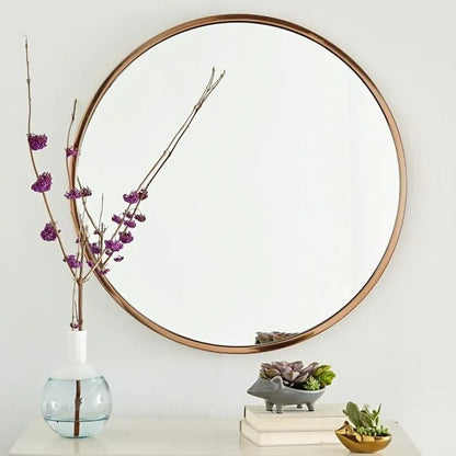 Round metal-framed wall mirror in black, white, or gold for bathroom.