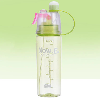 Green mist spray water bottle with clear volume scale and leakproof lid on a wooden table.