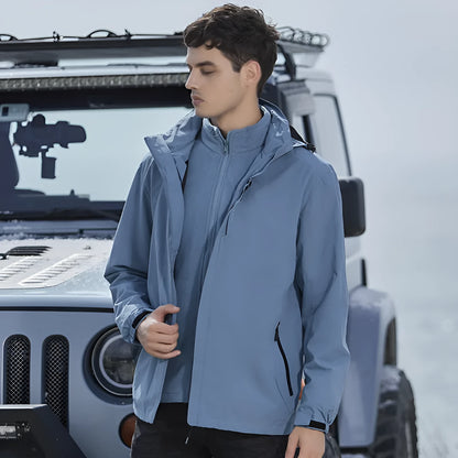 Men's fluorescent coloured waterproof mountaineering suit with removable fleece liner, shown in a hiking setting.