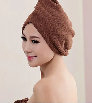 A woman wearing a sky blue microfiber hair dryer cap, with wet hair tucked inside, showing the towel's wrap-around design.