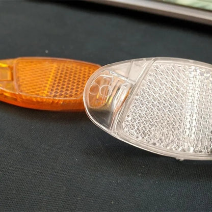 White and yellow plastic bicycle reflector for spoke mounting measuring 7.2 by 3.5 centimetres
