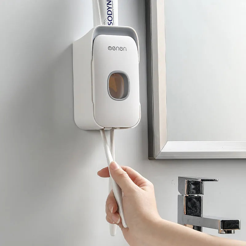 Automatic wall-mounted toothpaste dispenser in blue, grey, and pink colours with LED touch sensor.