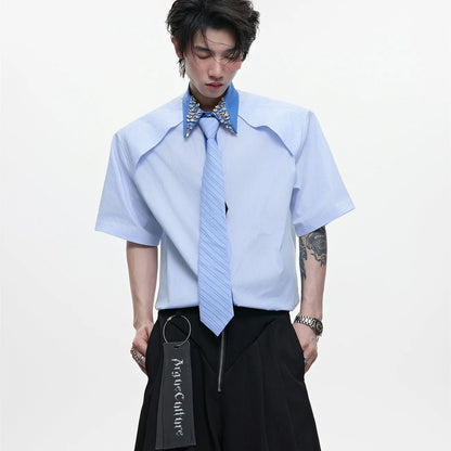 Man wearing a blue loose fit men's shirt with a diamond tie collar and patchwork striped design.