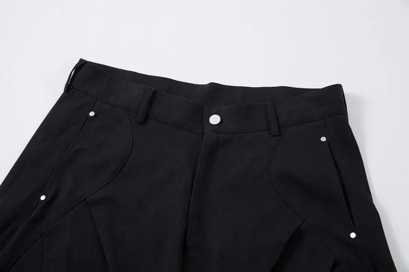 Men's black cotton pleated casual trousers with a loose-fitting wide-leg silhouette.